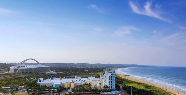 A coastal hotel with a modern stadium, beachfront, and a mix of residential and commercial buildings. - Hilton Durban (Durban)