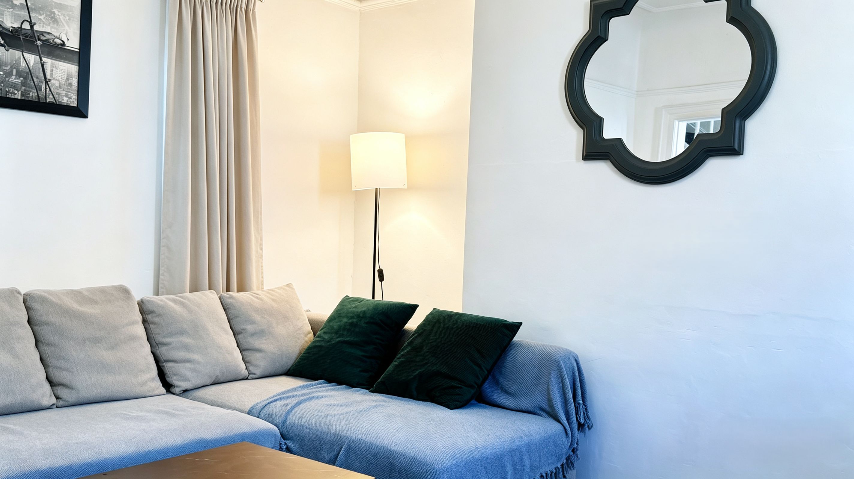 Un salon moderne avec un canapé, une lampe et un miroir.