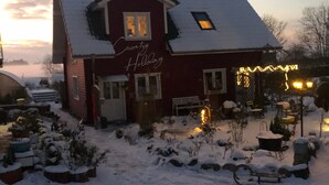 Ein rotes Gebäude mit verschneietem Dach und einem Schild mit der Aufschrift 'Country Holiday'.