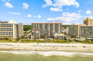 A beachfront hotel with multiple high-rise buildings, a sandy beach, and umbrellas. - Oceanview - Watch Dolphins from balcony - Parking (Myrtle Beach)