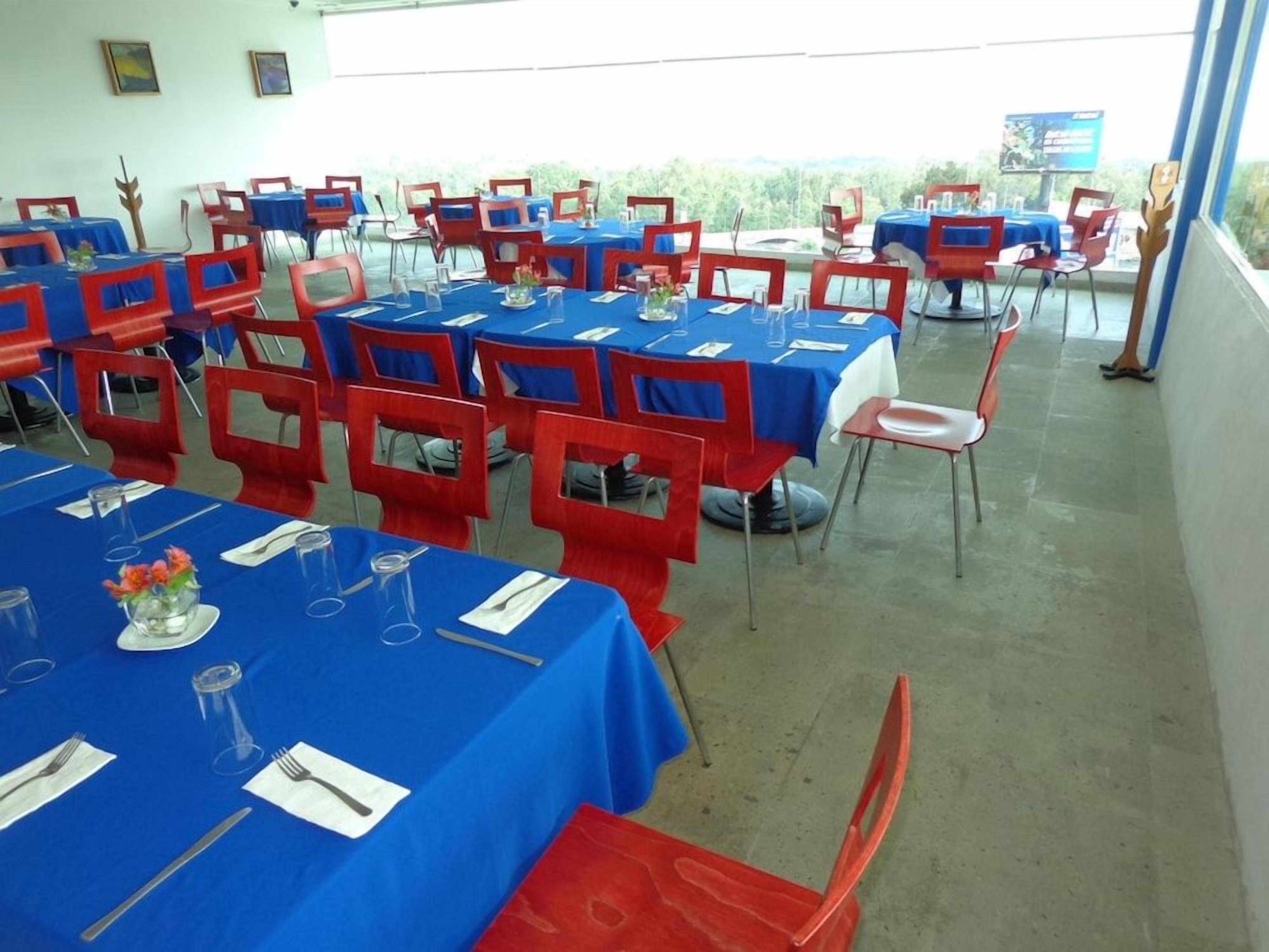 A room with multiple tables and chairs, arranged for dining.