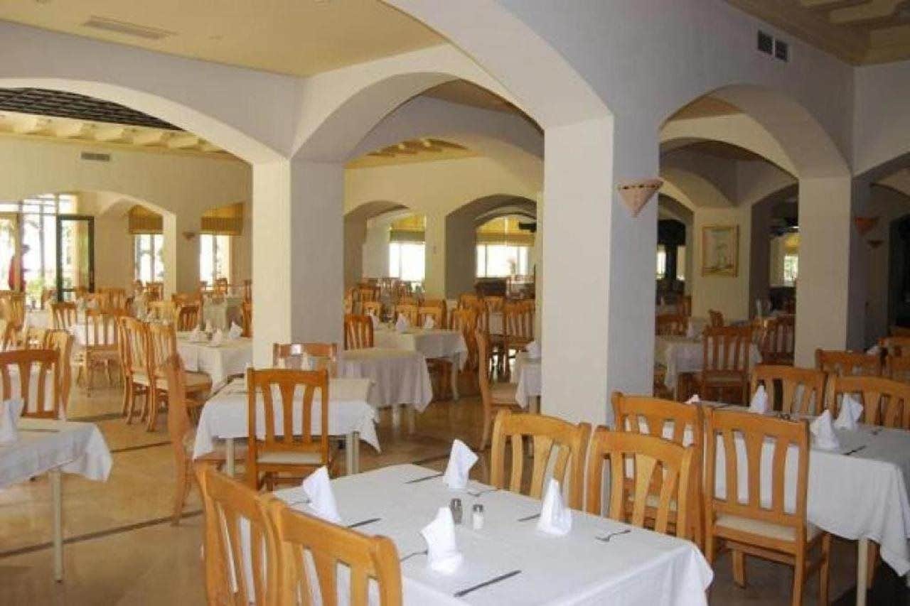 A dining area with tables and chairs, arched ceilings, and natural light.