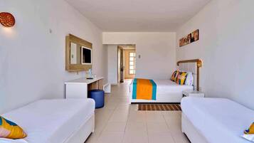 A hotel room with two single beds, a desk, a chair, a mirror, and a view of the hallway.