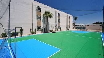 An indoor sports facility with multiple courts, including a basketball court and a soccer field.