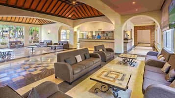 A spacious lobby with a checkered floor, sofas, and a coffee table.