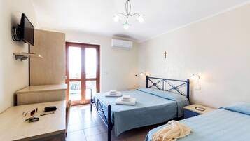 Una camera da letto con due letti, una scrivania, un televisore e un lampadario.
