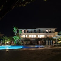 Un bâtiment à deux étages avec une piscine devant.