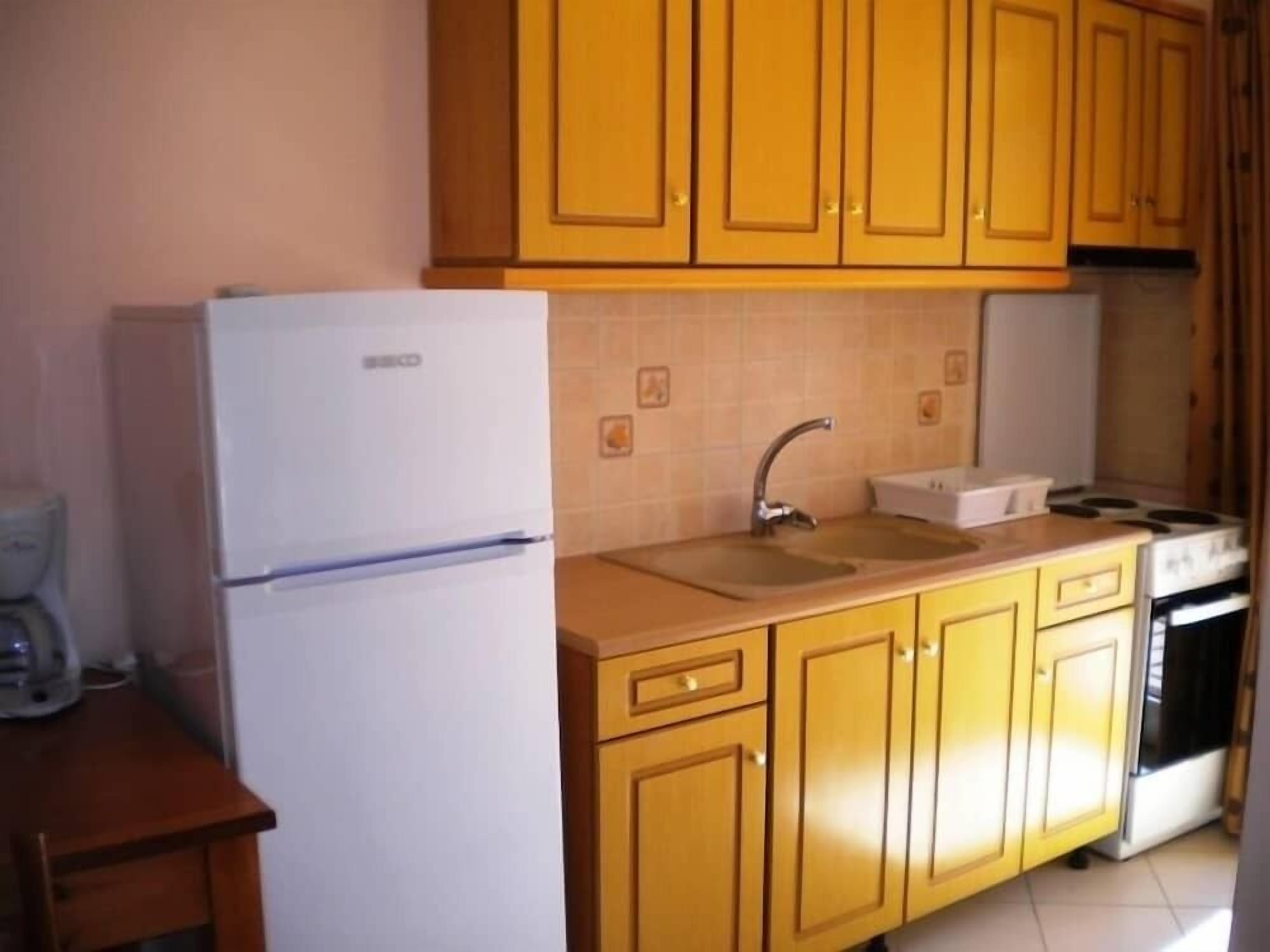 A kitchen with a white refrigerator, a sink, and a stove.