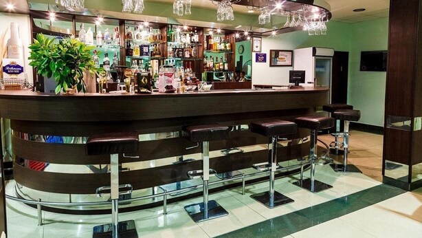 A bar area with stools, a counter, and various bottles. - Hotel Dalis (Nessebar)