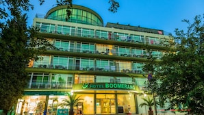 Een meerlaags hotel met een opvallend bord waarop 'HOTEL BOOMERANG' staat.