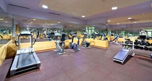 A gym with cardio machines, weightlifting equipment, and mirrors on the walls. - Heritage Hotel Kastelet (Tucepi)