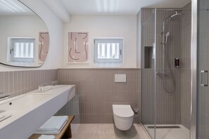 Un baño moderno con ducha, inodoro y lavamanos.