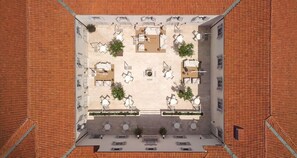 An overhead view of a courtyard with outdoor seating and a central fire pit. - Heritage Hotel Kastelet (Tucepi)
