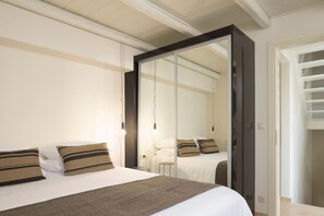 A bedroom with a bed, a wardrobe, and a mirror. - Eliathos Residence Houses Archanes (Archanes-Asterousia)