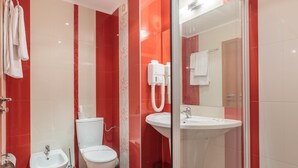 Ein modernes Badezimmer mit Duschkabine aus Glas, einem Bidet, einer Toilette und einem Waschbecken.