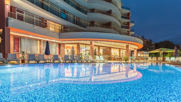 Ein Hotel mit Swimmingpool, Außenbereich zum Sitzen und mehreren Balkonen.