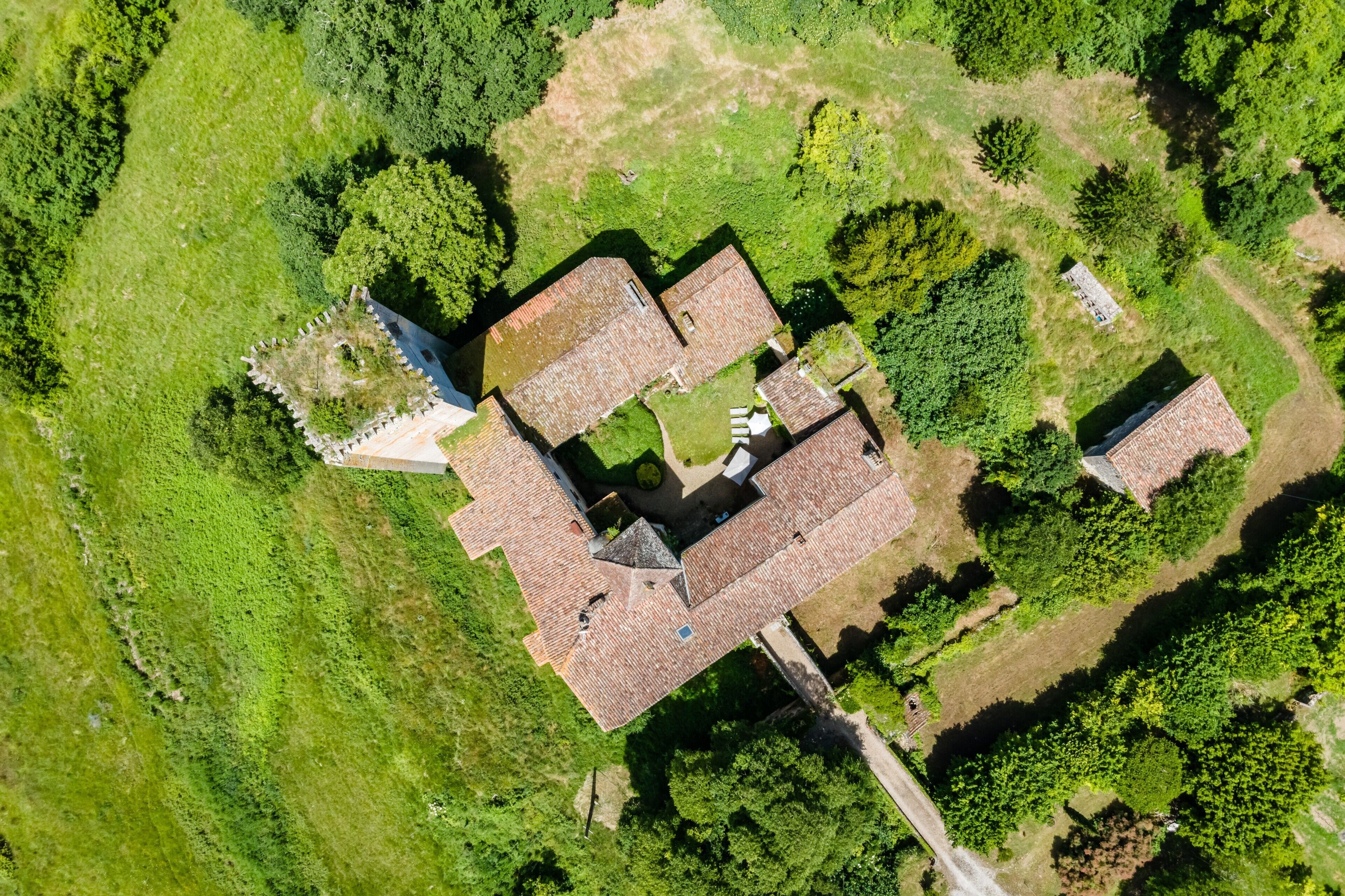 Vista aerea di una proprietà con diversi edifici, immersa nel verde.