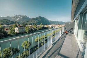 A balcony with a view of a river and mountains. - Aparthotel Goldey (Unterseen)