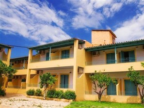 A multi-story hotel with balconies, a flat roof, and a clear sky. - Sirocco Hotel (Corfu)