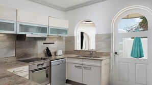 A modern kitchen with a built-in oven, dishwasher, and a large window. - Royal Westmoreland Cassia Heights 29 - by Zenbreak (Westmoreland)