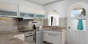 A modern kitchen with a built-in oven, dishwasher, and a large window.
