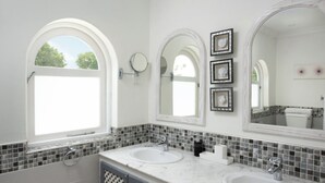 A bathroom with two sinks, a window, and a large mirror. - Royal Westmoreland Cassia Heights 29 - by Zenbreak (Westmoreland)