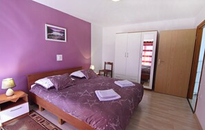 A bedroom with a bed, nightstand, lamp, wardrobe, and a mirror. - Comfortable Vacation Flat in a Great Area (Umag)