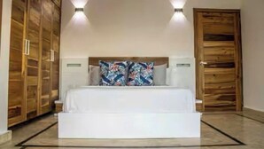 A bedroom with a bed, wooden wardrobe, and a door. - Beautiful and Cozy With sea Views (Las Terrenas)