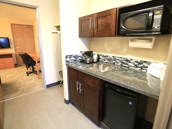 A compact kitchen with a microwave, sink, and a small countertop area.
