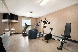 A fitness room with a treadmill, elliptical, and stationary bike. - Days Inn Calgary Airport (Calgary)