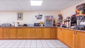 Una cocina con gabinetes de madera, microondas, tostadora y cafetera.