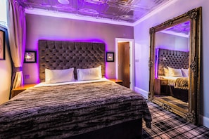 A bedroom with a tufted headboard, a large mirror, and purple ambient lighting. - Mercure Nottingham City Centre Hotel (Nottingham)