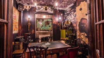 A room with a rustic wooden table, chairs, and a fireplace.