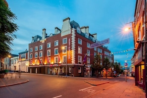 A historic building with a red facade, multiple windows, and a sign indicating a hotel.