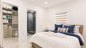 Ein Schlafzimmer mit Bett, begehbarer Kleiderschrank und Dusche.