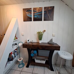 A bathroom with a wooden vanity, a toilet, a sink, and a shower area.