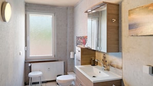 Un bagno con il water, un lavandino e una finestra.