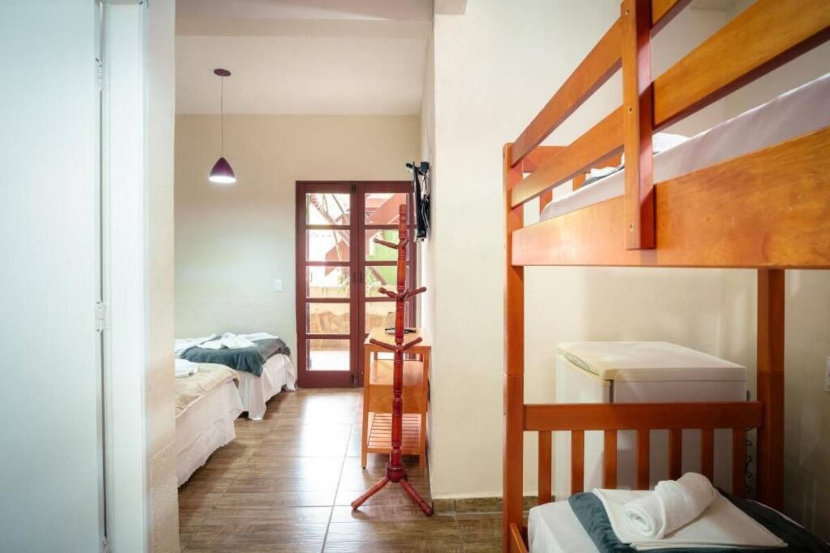 A room with bunk beds, a desk, and a standing lamp.