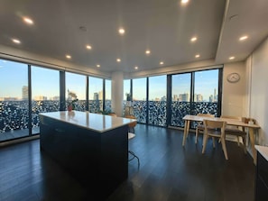 A modern interior with a large window, a central island, and a dining area.