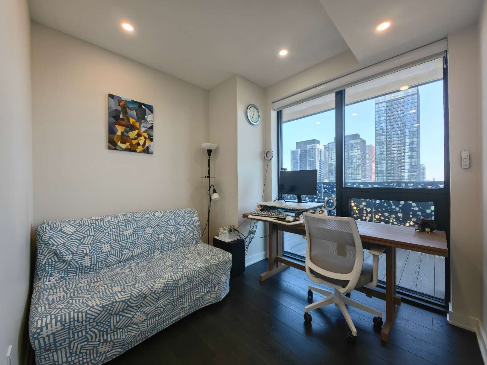 A modern office space with a desk, chair, and a large window with a city view.