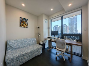 A modern office space with a desk, chair, and a large window with a city view.