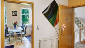 A room with a dining table, chairs, a radiator, and a staircase. - Spacious Apartment for up to 5 Guests (72 m²) in Hohenhameln (Hohenhameln)