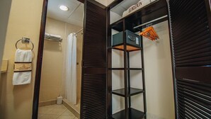 Habitación de hotel con vestidor, perchero y zona de ducha.