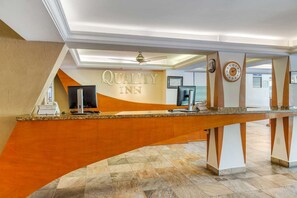A reception desk with a 'Quality Inn' sign, a clock, and a ceiling fan. - Eco City Hotel (Tuxtla Gutierrez)