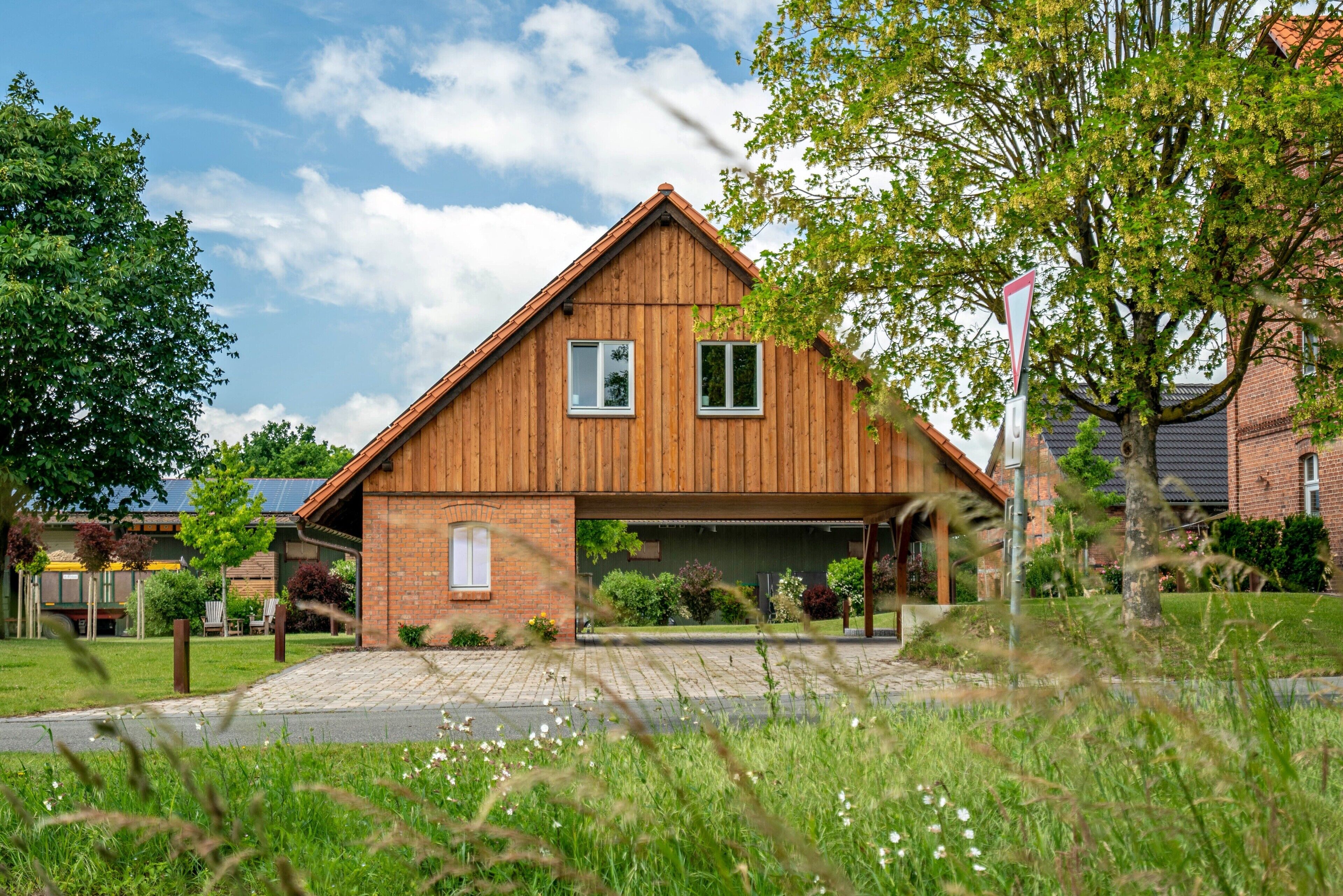 A two-story house with a sloped roof, a garage, and a brick exterior.