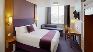 A hotel room with a large bed, a desk, a chair, a sofa, and a TV. - Premier Inn Solihull South Hotel (Solihull)