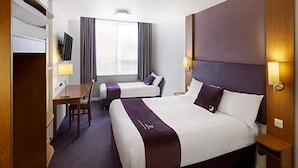 A hotel room with a large bed, a smaller bed, a desk, and a TV. - Premier Inn Solihull South Hotel (Solihull)