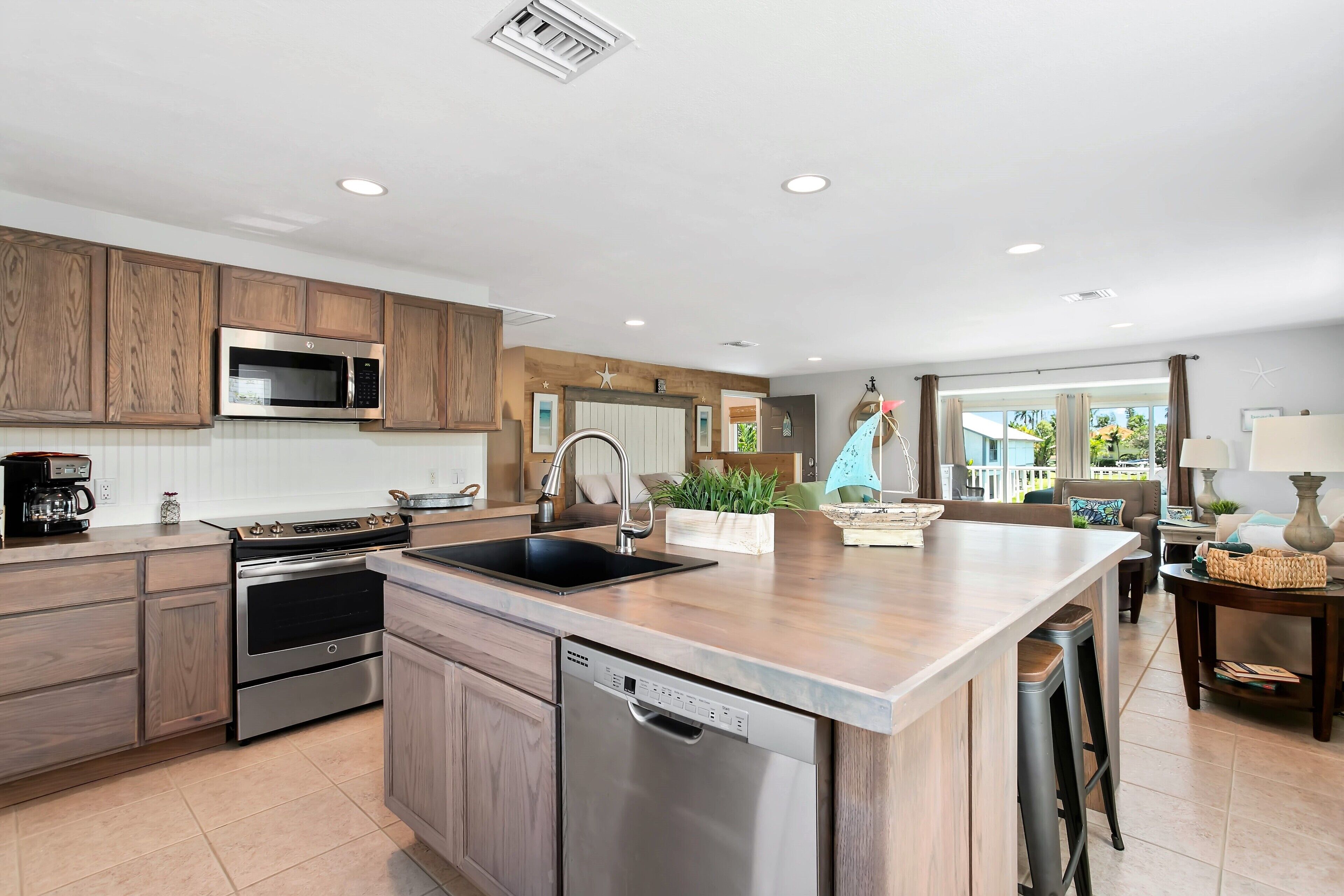 A modern kitchen with wooden cabinets, stainless steel appliances, and a central island.