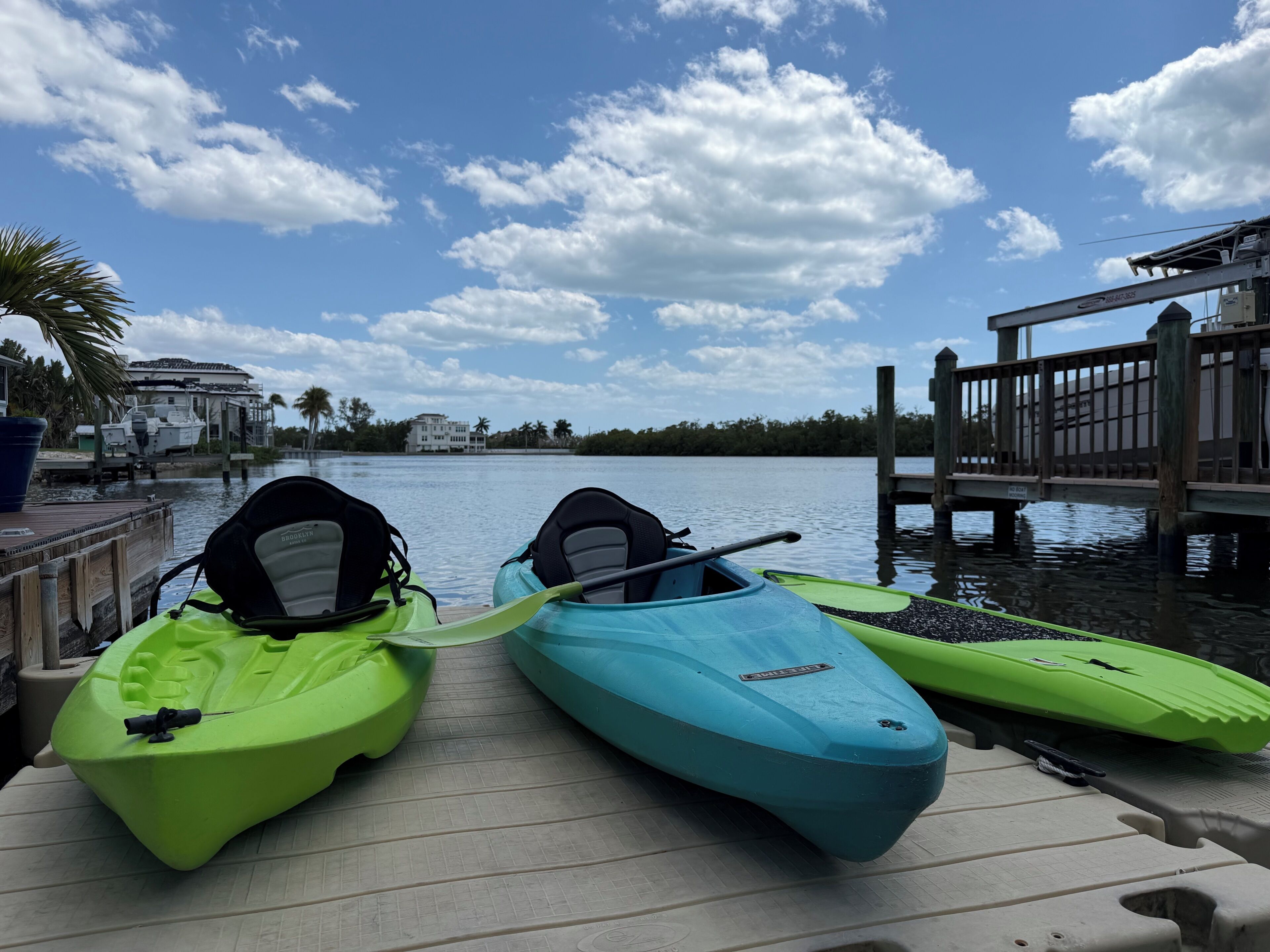 Un quai où sont amarrés des kayaks et une jetée en bois qui s’avance dans une étendue d’eau calme.