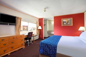 A hotel room with a bed, a TV, a desk, and a chair. - Travelodge by Wyndham Pigeon Forge (Pigeon Forge)